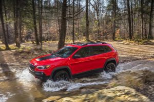 Jeep Cherokee 2019 color rojo en bosque sobre río