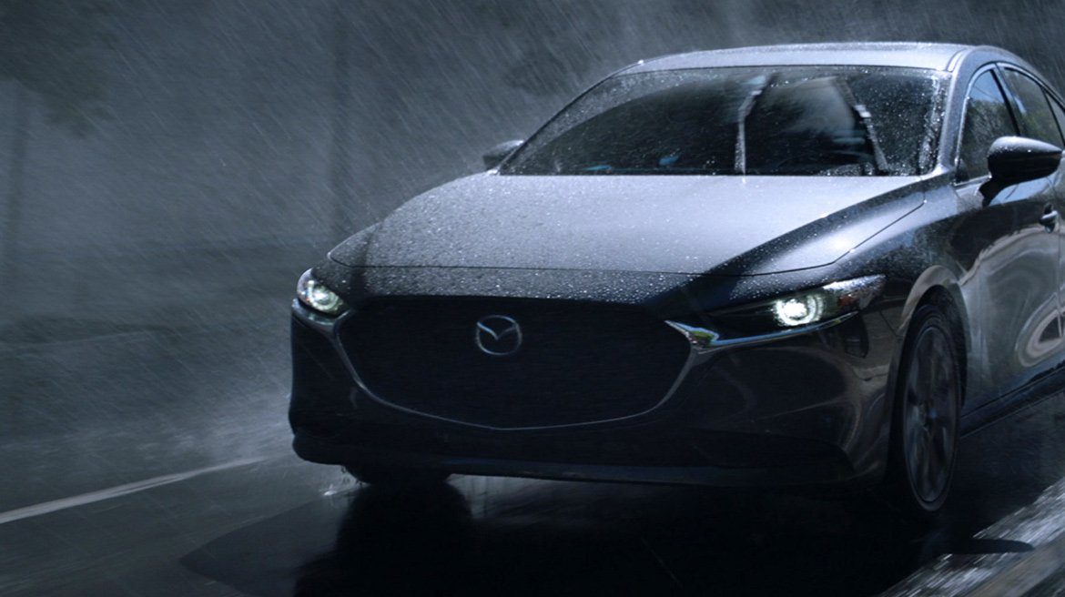 Mazda 3 sedán 2022 en México frente con parrilla y faros LED, en calle con lluvia
