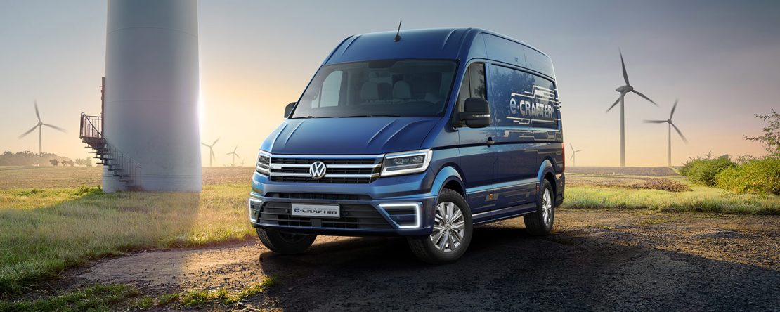 Volkswagen e-Crafter Van eléctrica llega a México pronto - color azul estacionada en paisaje con torres eólicas