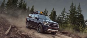 Ford Expedition Timberline 2024 - diseño exterior color negro, en campo, con terracería y maletas en reja superior del toldo