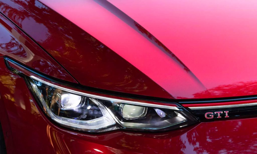Volkswagen GTI 2024 en México - color Rojo, diseño exterior acercamiento a los faros LED frontales y emblema GTI