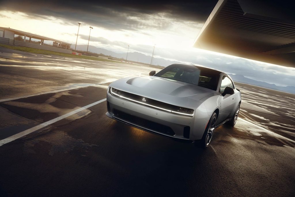 Dodge Charger 2024 eléctrico - exterior - color plata - con techo negro, frente, defensa, faros LED, cofre, rines con cielo nublado en autoipista