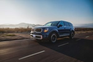 Kia Telluride 2024 en México - exterior en carretera - frente y lateral, defensa, faros, rines, atardecer en México