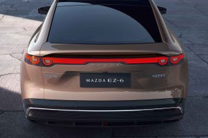 Mazda EZ-6 2025 100% eléctrico - diseño exterior - parte posterior cajuela, placa, emblema, faros LED, color cobre
