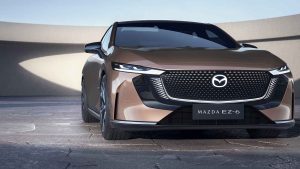 Mazda EZ-6 2025 100% eléctrico - diseño exterior - color cobre - parte frontal, emblema, faros LED, parrilla