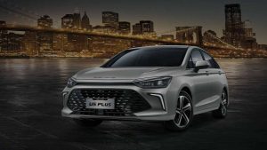 BAIC U5 Plus 2025 en México, exterior: frente y lateral, defensa, luces LED, rines. Estacionado en ciudad al fondo, edificios y puente